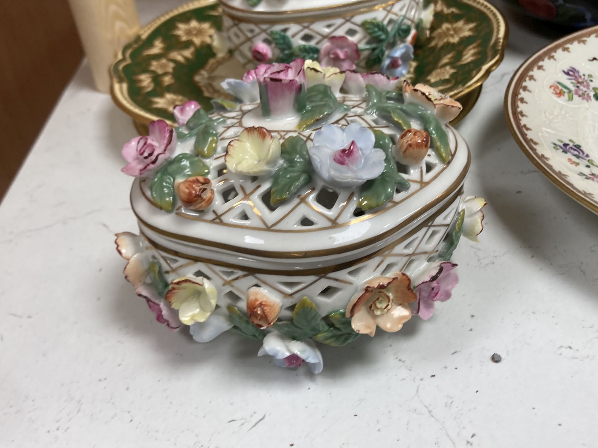 A Continental porcelain shaped oval posy basket encrusted with carnations and sundry ceramics,